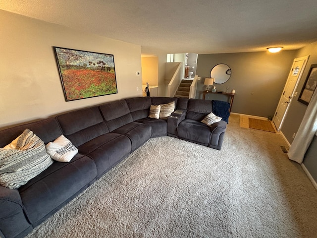 living area with carpet flooring, a textured ceiling, stairs, and baseboards