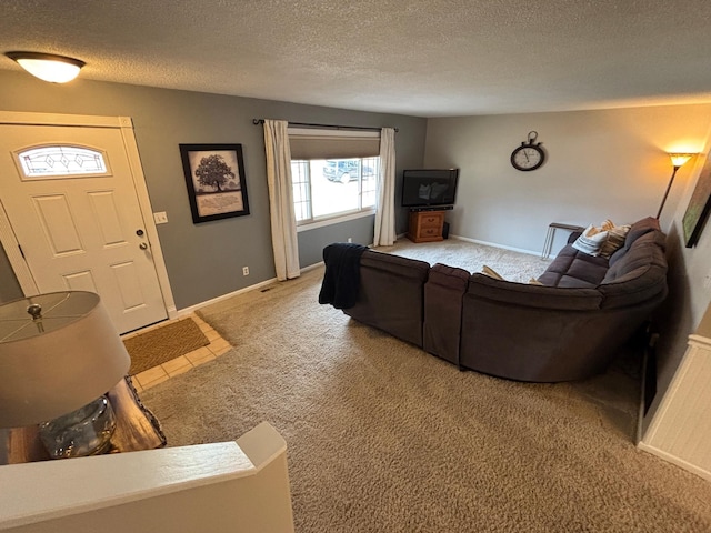 living room with baseboards, light carpet, a textured ceiling, and visible vents