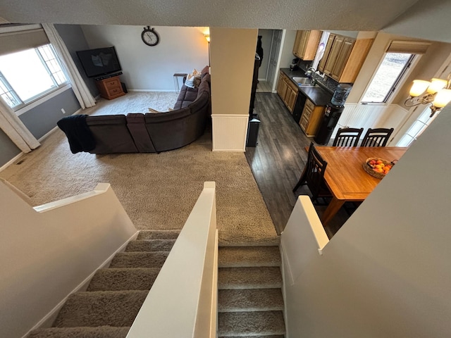 staircase with wood finished floors, baseboards, and a chandelier