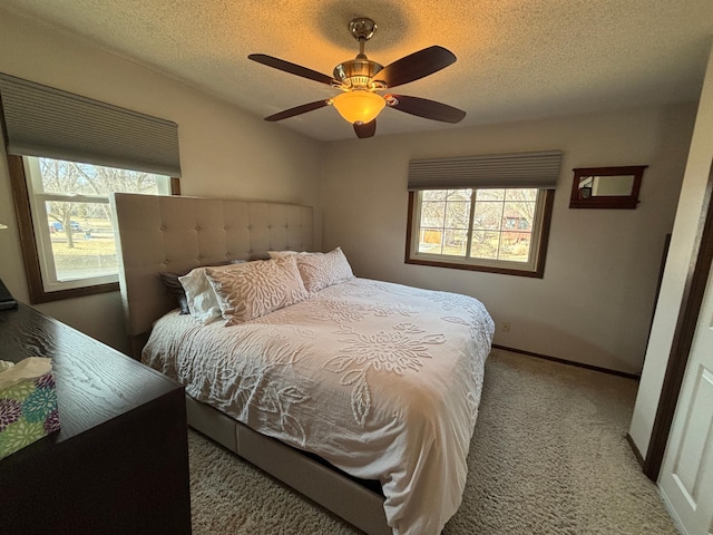 bedroom featuring baseboards, a textured ceiling, carpet, and a ceiling fan