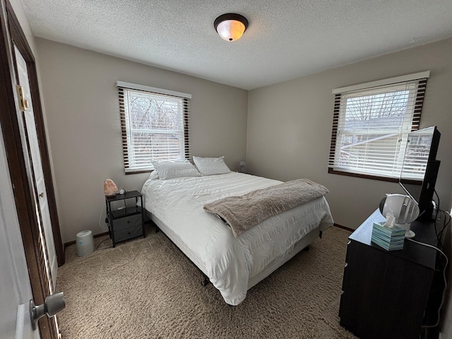 carpeted bedroom with baseboards and a textured ceiling