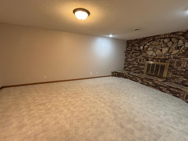 unfurnished living room with a fireplace, baseboards, carpet floors, and a textured ceiling