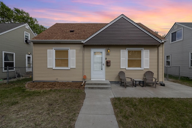 bungalow with a patio and roof with shingles