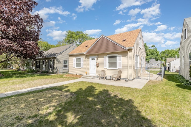 rear view of house with a shingled roof, a gate, and a patio