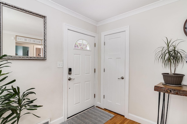 entryway featuring light wood-style flooring, crown molding, and baseboards