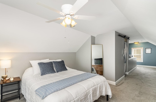 carpeted bedroom featuring vaulted ceiling, baseboards, a barn door, and ceiling fan