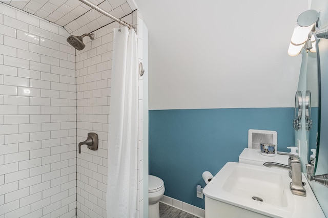 full bath featuring toilet, tiled shower, and vanity
