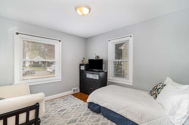bedroom featuring wood finished floors and baseboards