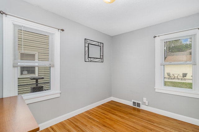 spare room with light wood finished floors and baseboards