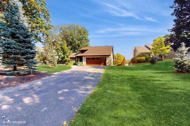 view of front of property with an attached garage, driveway, and a front lawn