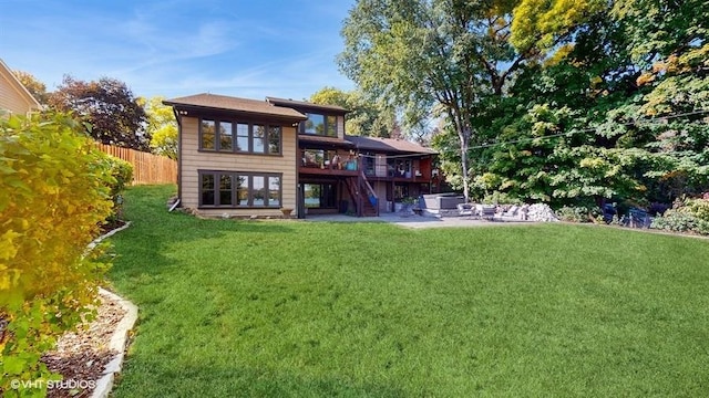 back of house featuring a deck, a patio, fence, a yard, and stairway