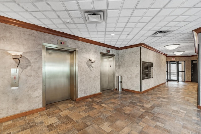 empty room featuring elevator, baseboards, stone finish floor, and ornamental molding