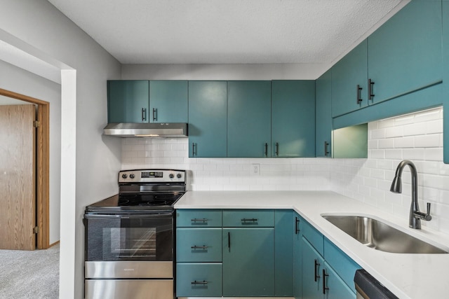 kitchen with under cabinet range hood, carpet floors, a sink, light countertops, and appliances with stainless steel finishes