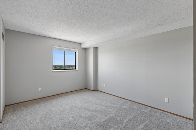 carpeted empty room with a textured ceiling and baseboards