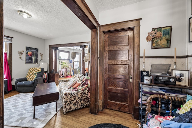 living room featuring wood-type flooring and a textured ceiling