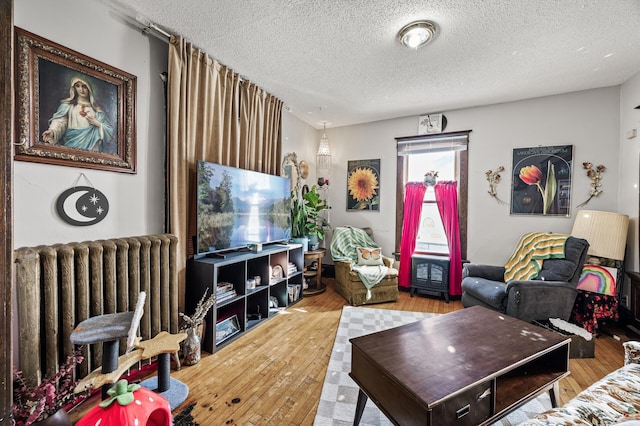 living room featuring radiator, a textured ceiling, and wood-type flooring