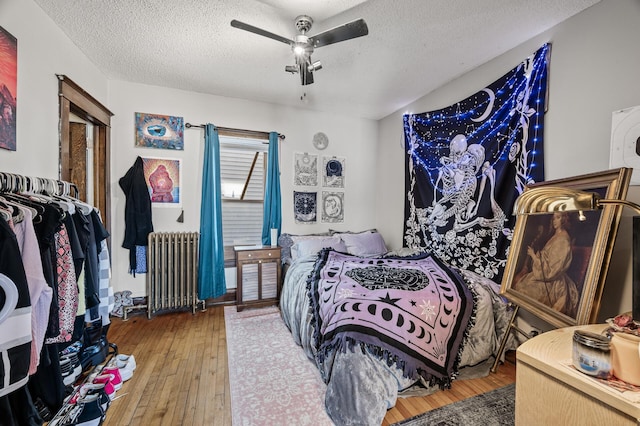 bedroom featuring radiator, a textured ceiling, ceiling fan, and hardwood / wood-style flooring