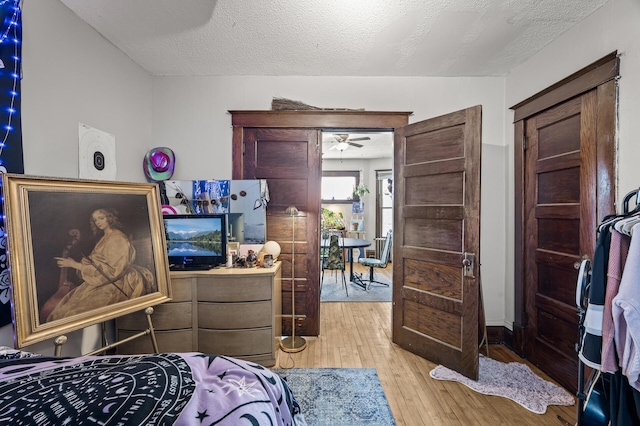 bedroom featuring light wood-style flooring and a textured ceiling