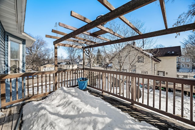 snow covered deck with a residential view and a pergola