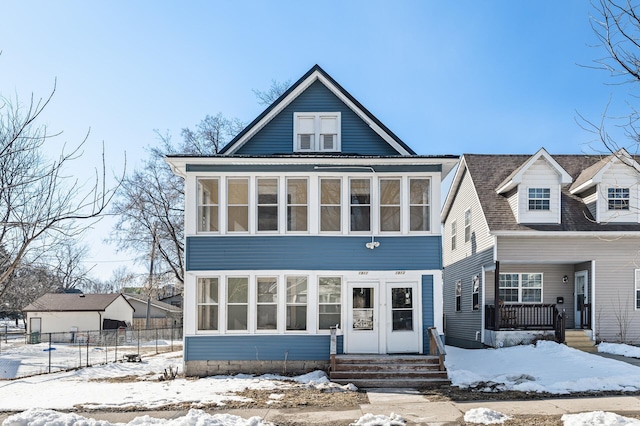 view of front of house featuring a sunroom, entry steps, and fence