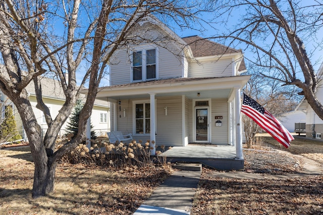 american foursquare style home with roof with shingles and covered porch