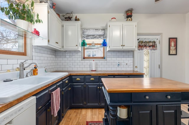 kitchen featuring blue cabinets, white cabinets, white dishwasher, and a sink