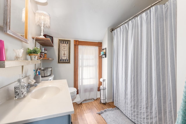 bathroom with curtained shower, toilet, vanity, and wood finished floors