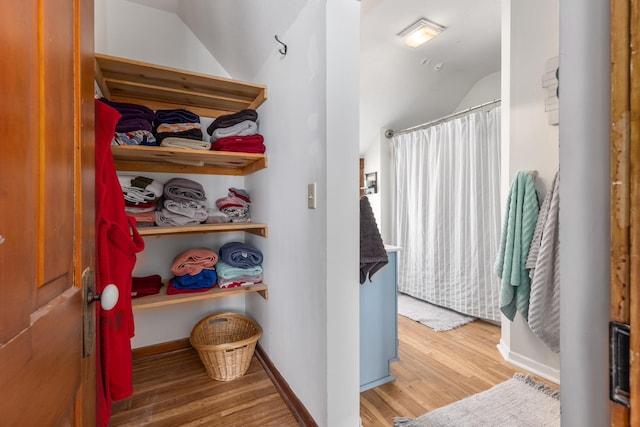 bathroom featuring curtained shower, wood finished floors, and baseboards