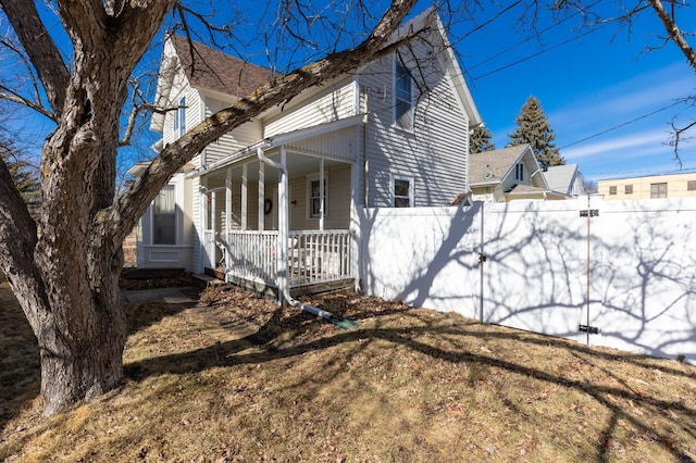 view of property exterior featuring a porch and fence