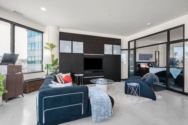 living area with concrete flooring, recessed lighting, and visible vents