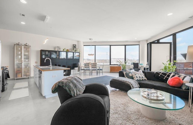 living area featuring concrete flooring, visible vents, and recessed lighting