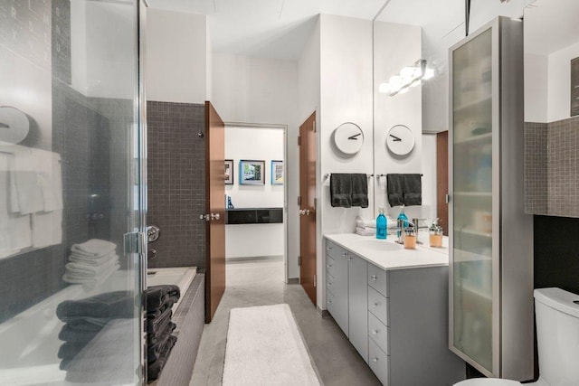 bathroom with a bathtub, a stall shower, vanity, and toilet