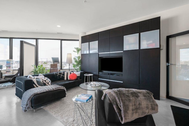 living area featuring recessed lighting, concrete flooring, and a wealth of natural light