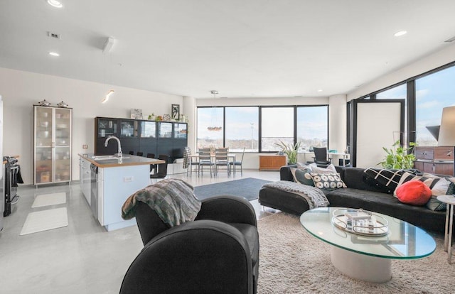 living area featuring recessed lighting, visible vents, and finished concrete flooring