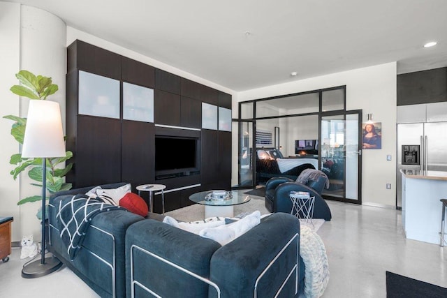 living room featuring recessed lighting, baseboards, and finished concrete flooring