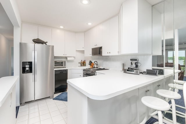 5430 Three Points Blvd Unit 131, Mound, MN 55364 - kitchen featuring black appliances, a peninsula, backsplash, light countertops, and white cabinetry