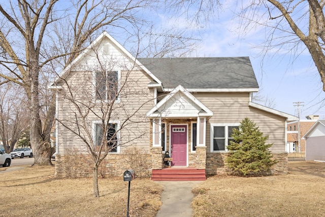 view of front of house with stone siding and roof with shingles