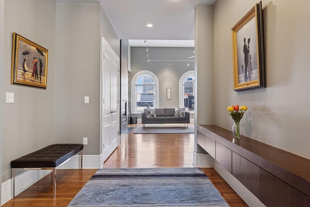 hall featuring recessed lighting, baseboards, and wood finished floors