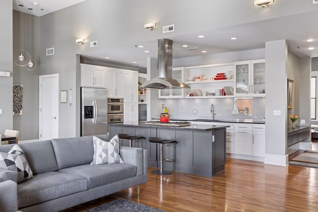 living area with recessed lighting, visible vents, and wood finished floors