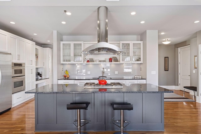 kitchen featuring light wood-style flooring, a center island, recessed lighting, stainless steel appliances, and island range hood