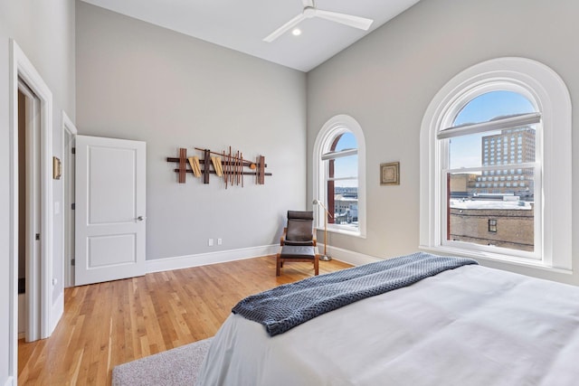 bedroom featuring ceiling fan, baseboards, recessed lighting, wood finished floors, and high vaulted ceiling