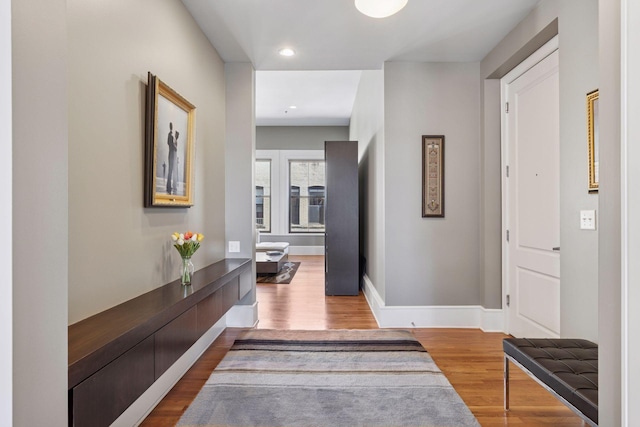 hallway featuring recessed lighting, wood finished floors, and baseboards