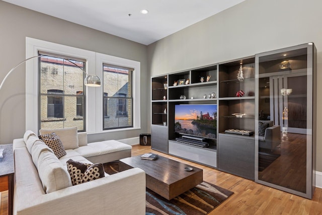 living area featuring recessed lighting, baseboards, and light wood-style floors