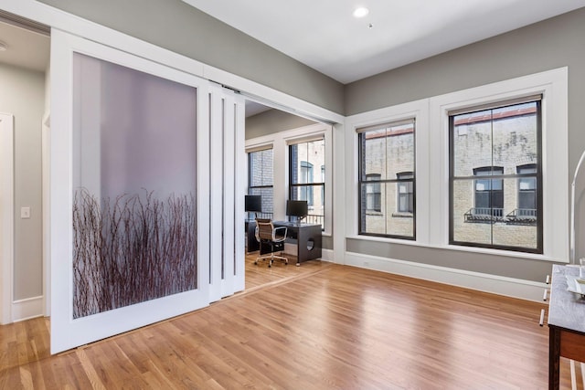 interior space with recessed lighting, wood finished floors, and baseboards