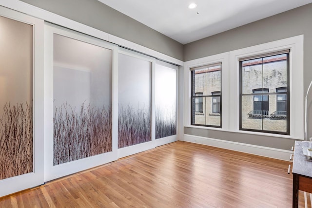 spare room featuring recessed lighting, baseboards, and wood finished floors