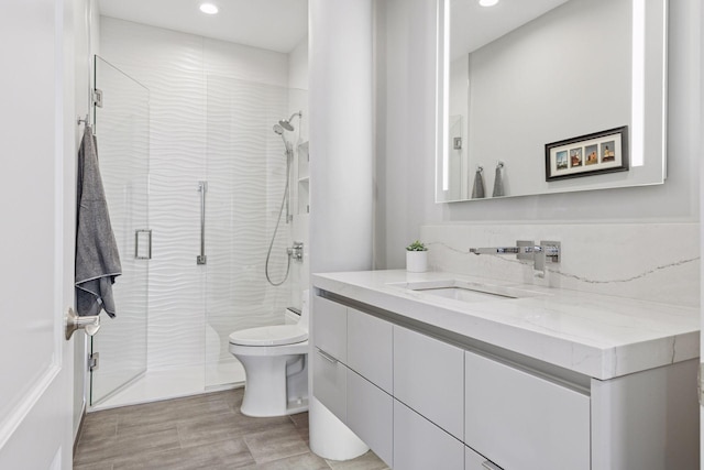 full bath featuring recessed lighting, a stall shower, toilet, and vanity