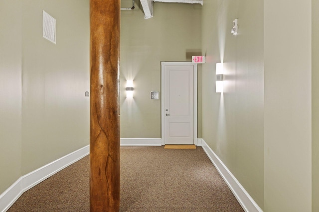 hallway featuring carpet flooring, visible vents, and baseboards