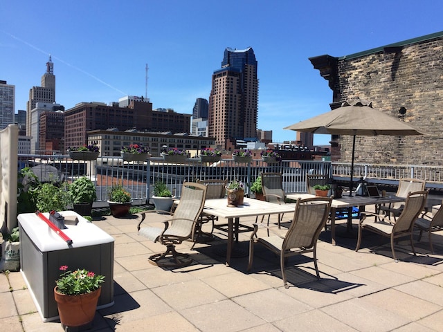 view of patio / terrace with a city view, outdoor dining space, and fence