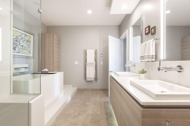 bathroom featuring double vanity, radiator heating unit, recessed lighting, and a sink