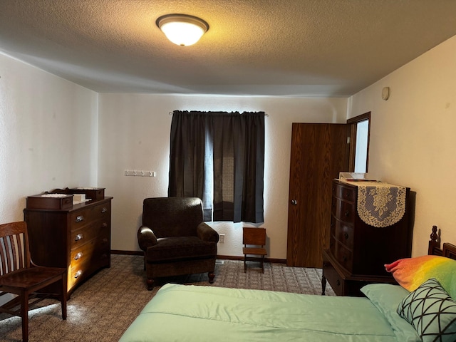 bedroom with a textured ceiling and baseboards